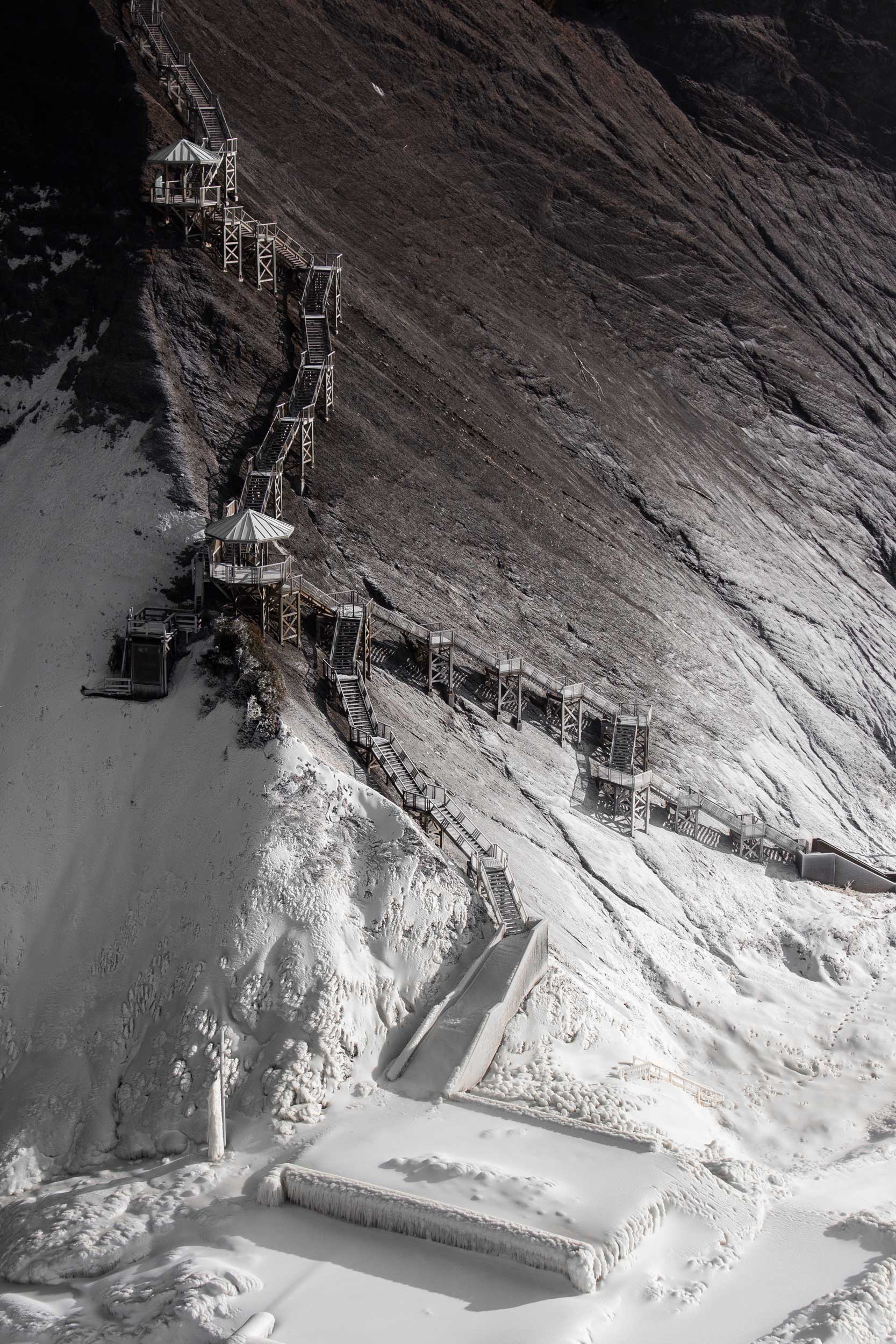 Ein Weg am schneebedeckten Berghang.