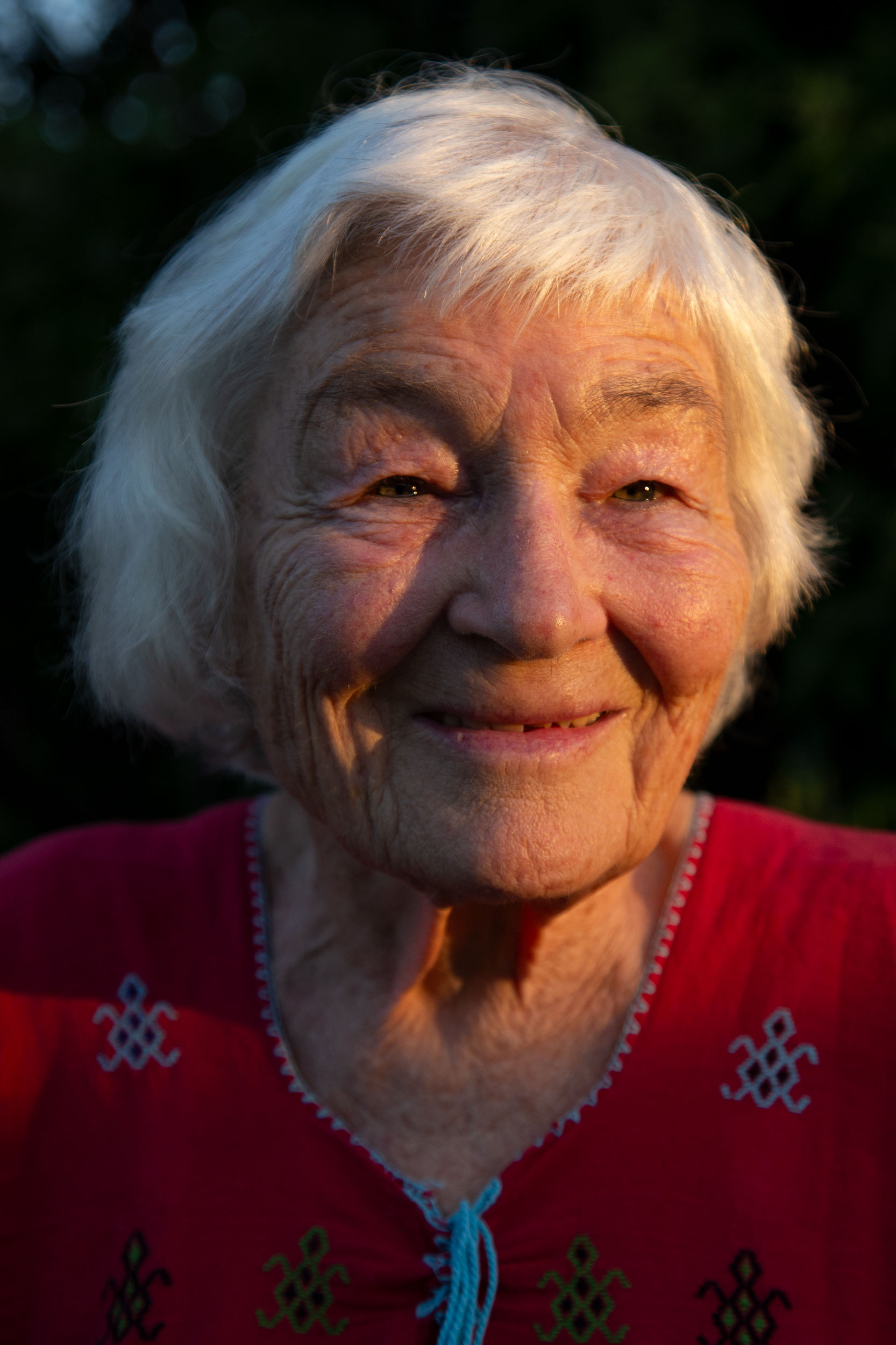 Eine alte Dame mit freundlichem Lächeln im Gesicht.